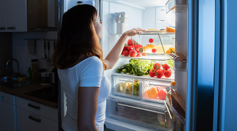 woman looking in fridge